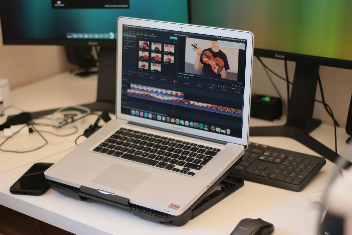A creator experimenting with a web-based AI video generator interface on a laptop, surrounded by creative tools. | Photo by Adam Sondel on Pexels